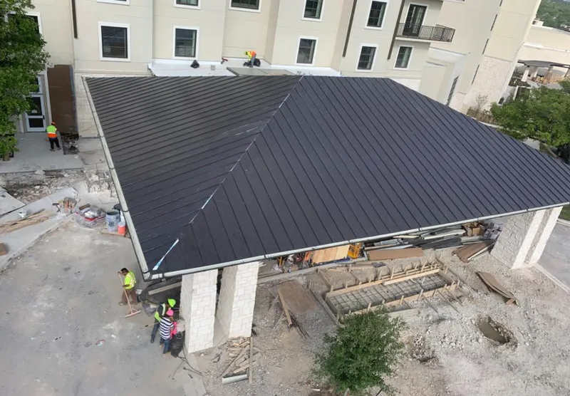 Metal roofing installation team working on a commercial building in El Cerro Mission